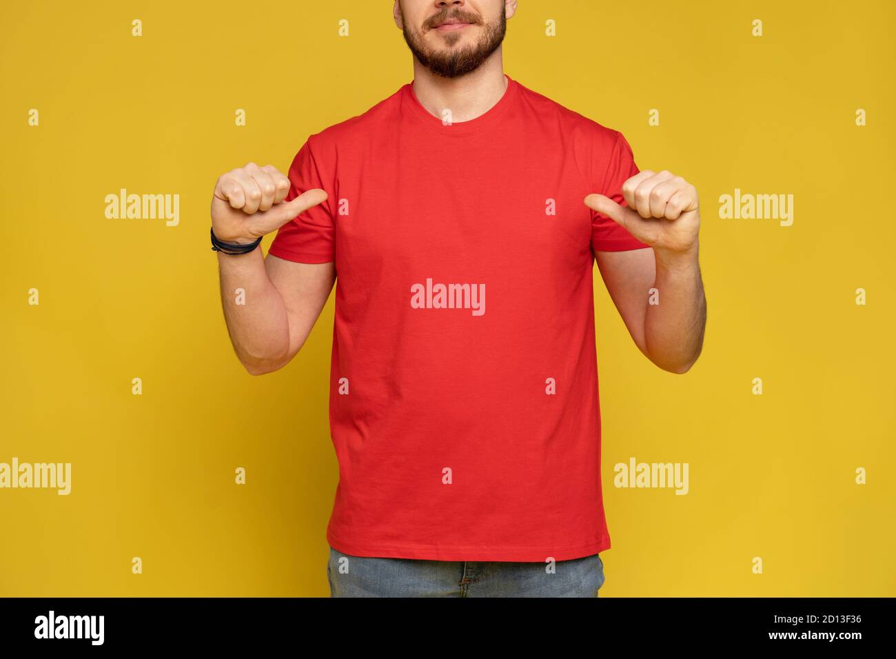 Happy man from delivery service in red t-shirt and cap isolated over yellow Stock Photo
