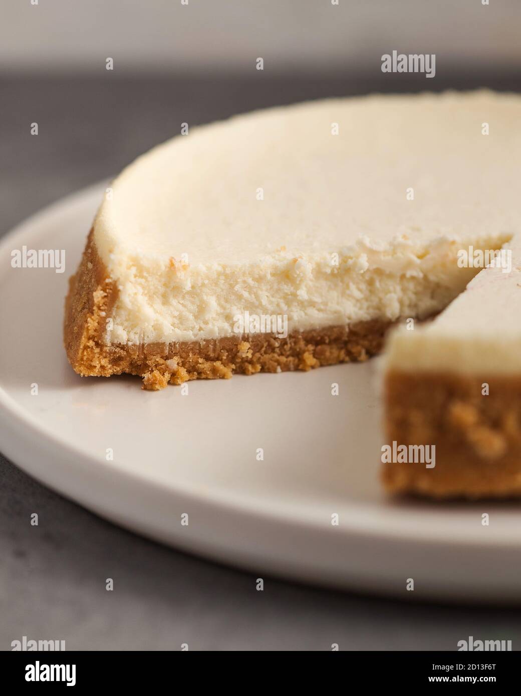 Cut cheesecake cake closeup on a white plate Stock Photo - Alamy