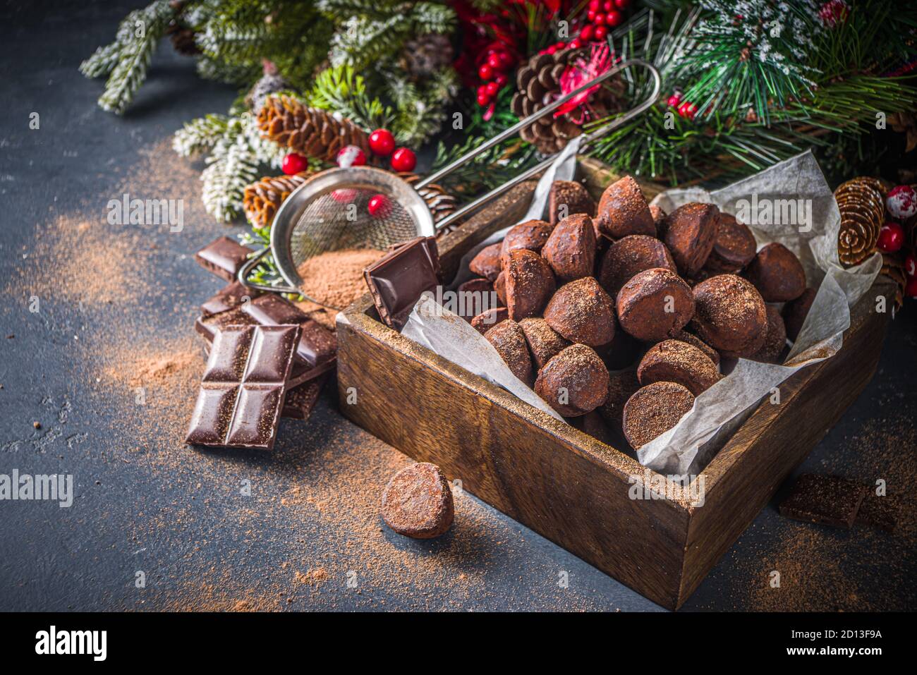 Traditional Christmas dessert, homemade chocolate truffles, with dark chocolate slices, winter spices and christmas tree decor on dark  background. co Stock Photo