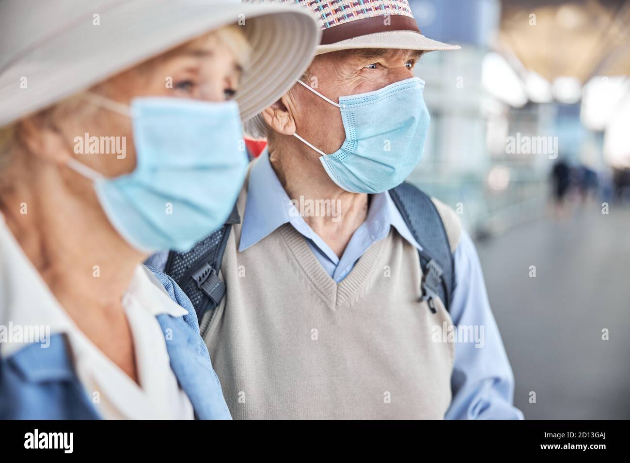 Two elderly people in face masks looking away Stock Photo
