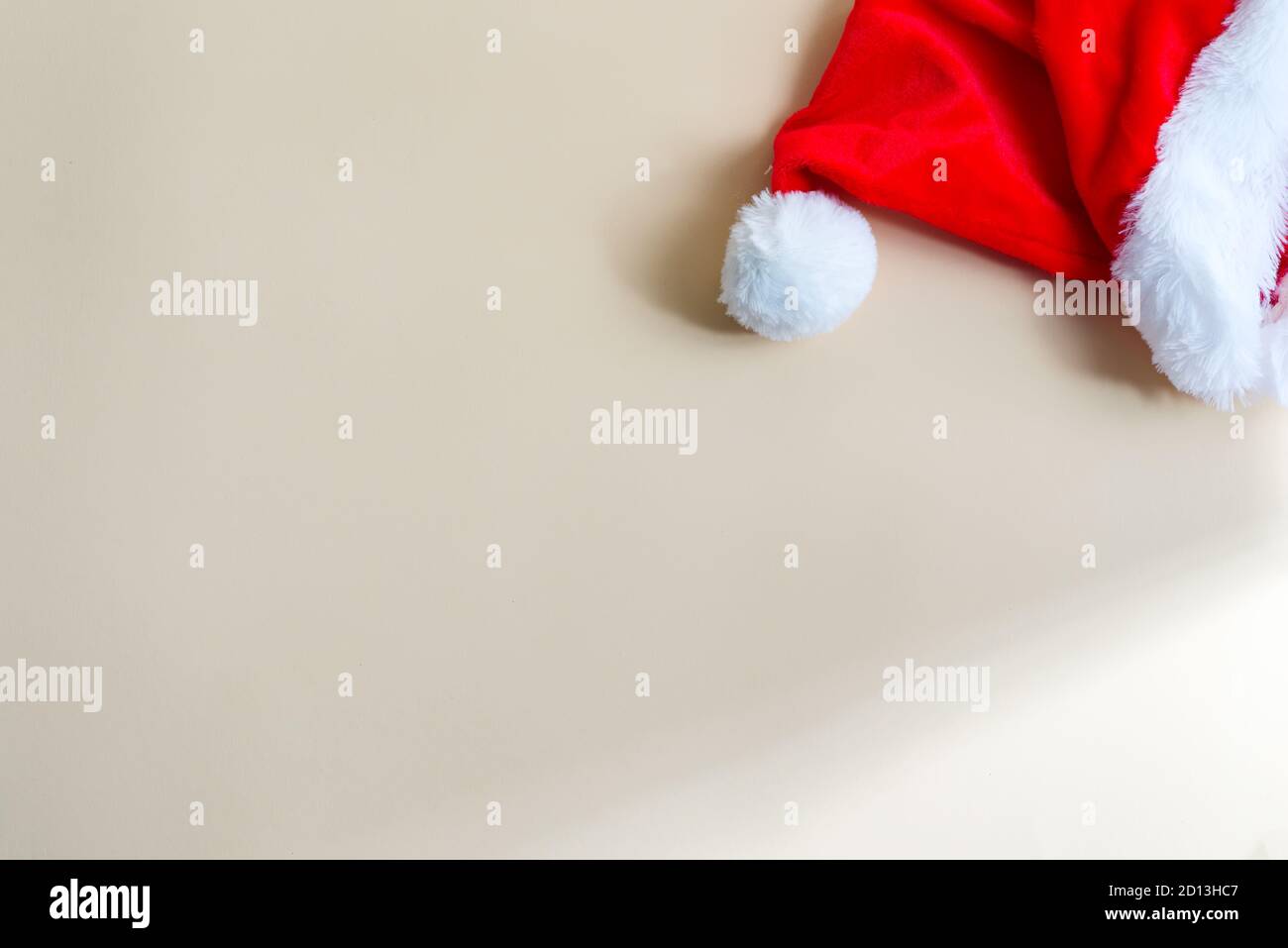 Red Santa Claus hat on a light beige background. Stock Photo