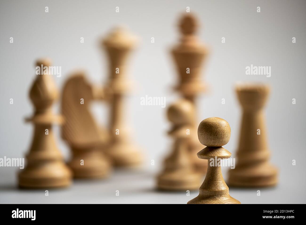 different chess pieces out of focus in the background, only one pawn in focus in the foreground Stock Photo