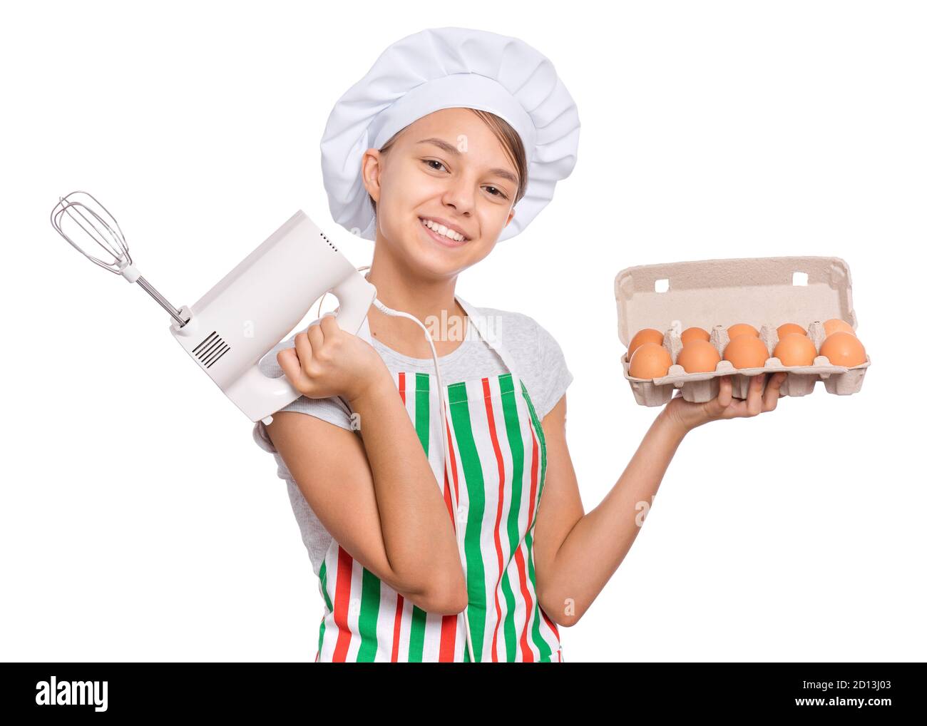 Teen girl in chef hat in apron with egg beater, isolated on white