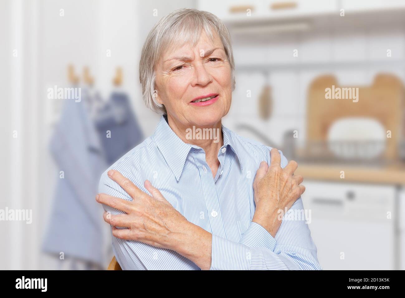 Polymyalgia rheumatica: elderly woman with acute pain in her upper arms and shoulders. Stock Photo