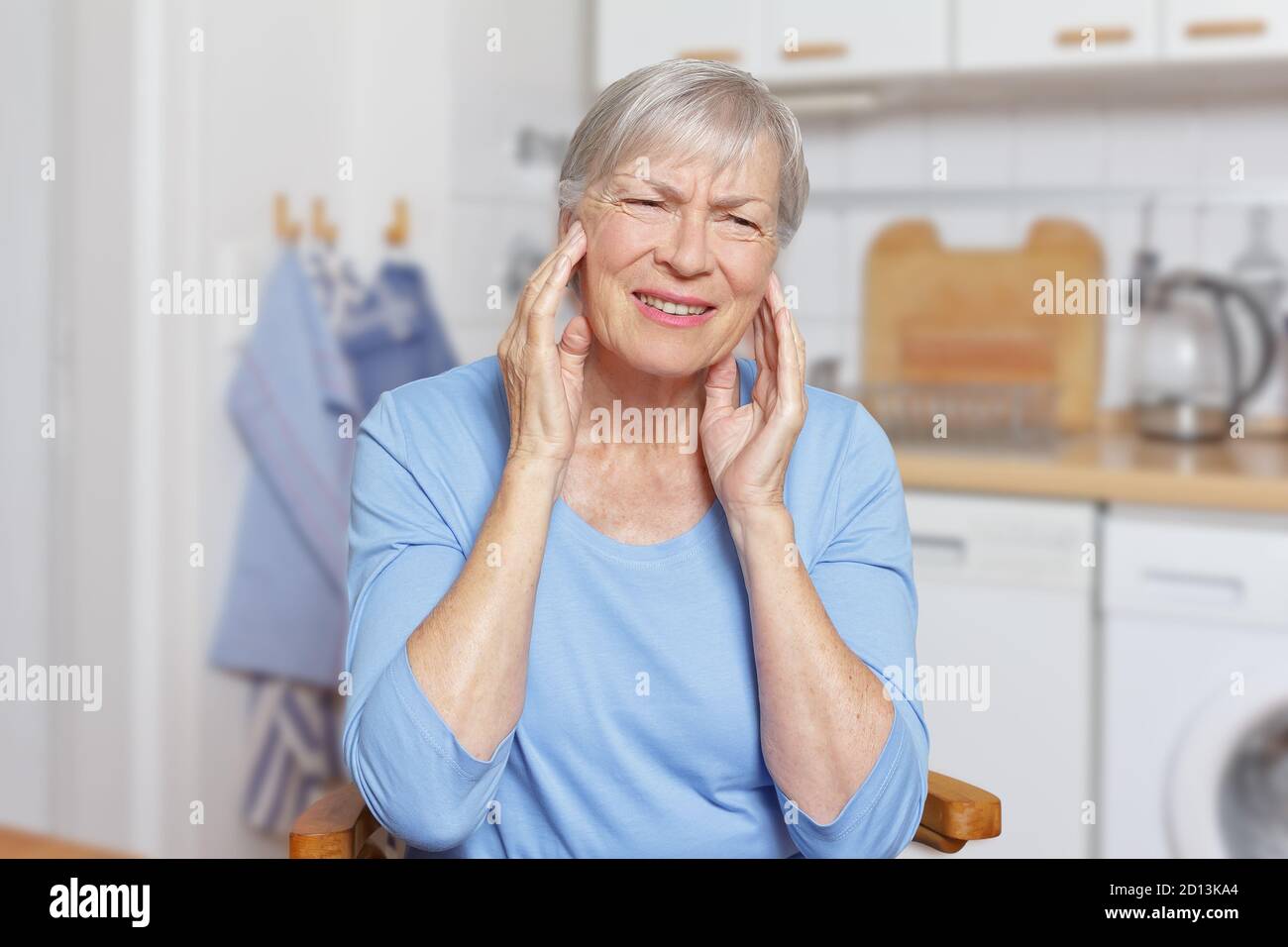 Temporal arteritis: elderly woman suffering from painful jaw joints. Stock Photo