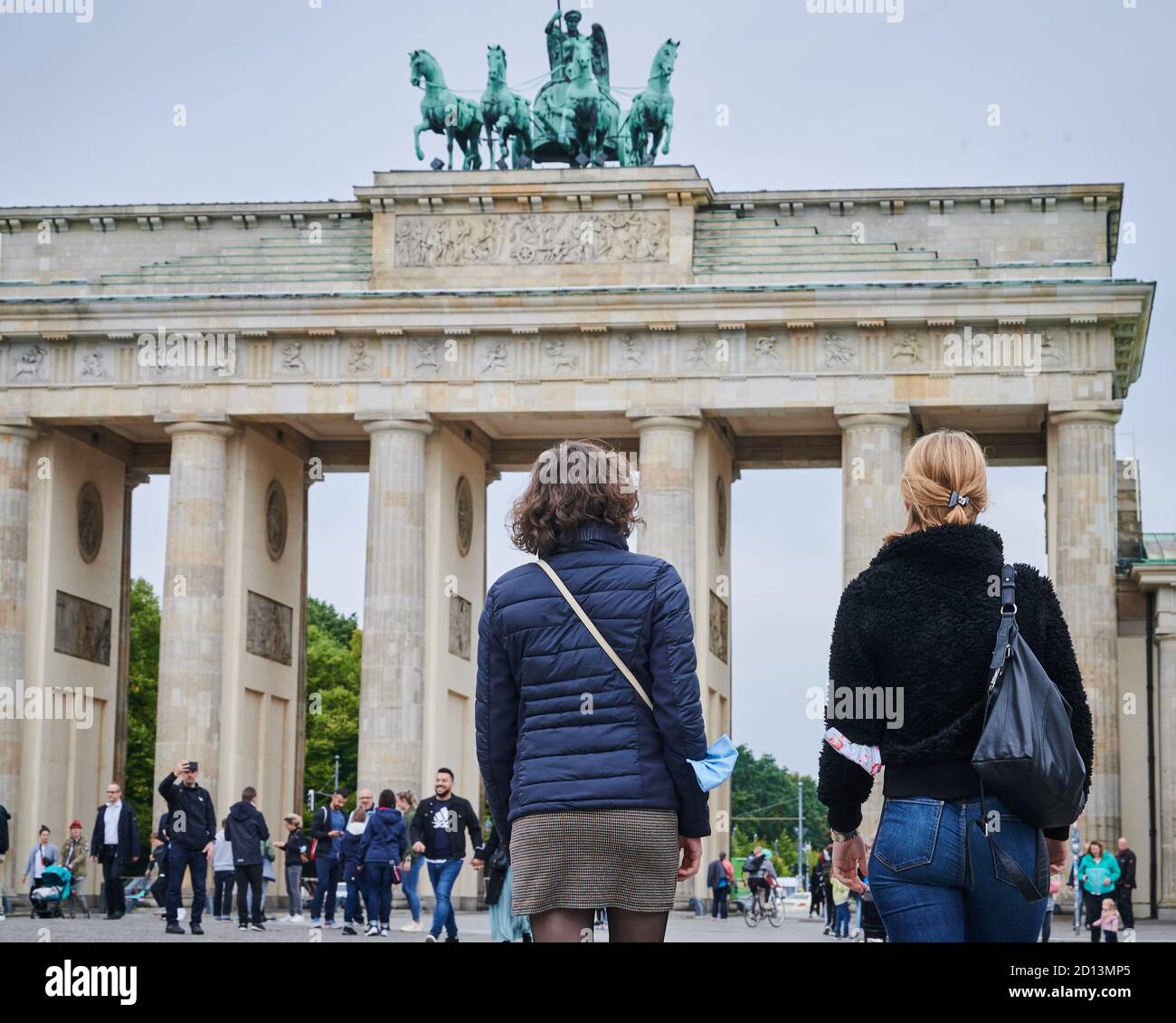 05 October 2020, Berlin: Two women walk in front of the Brandenburg ...