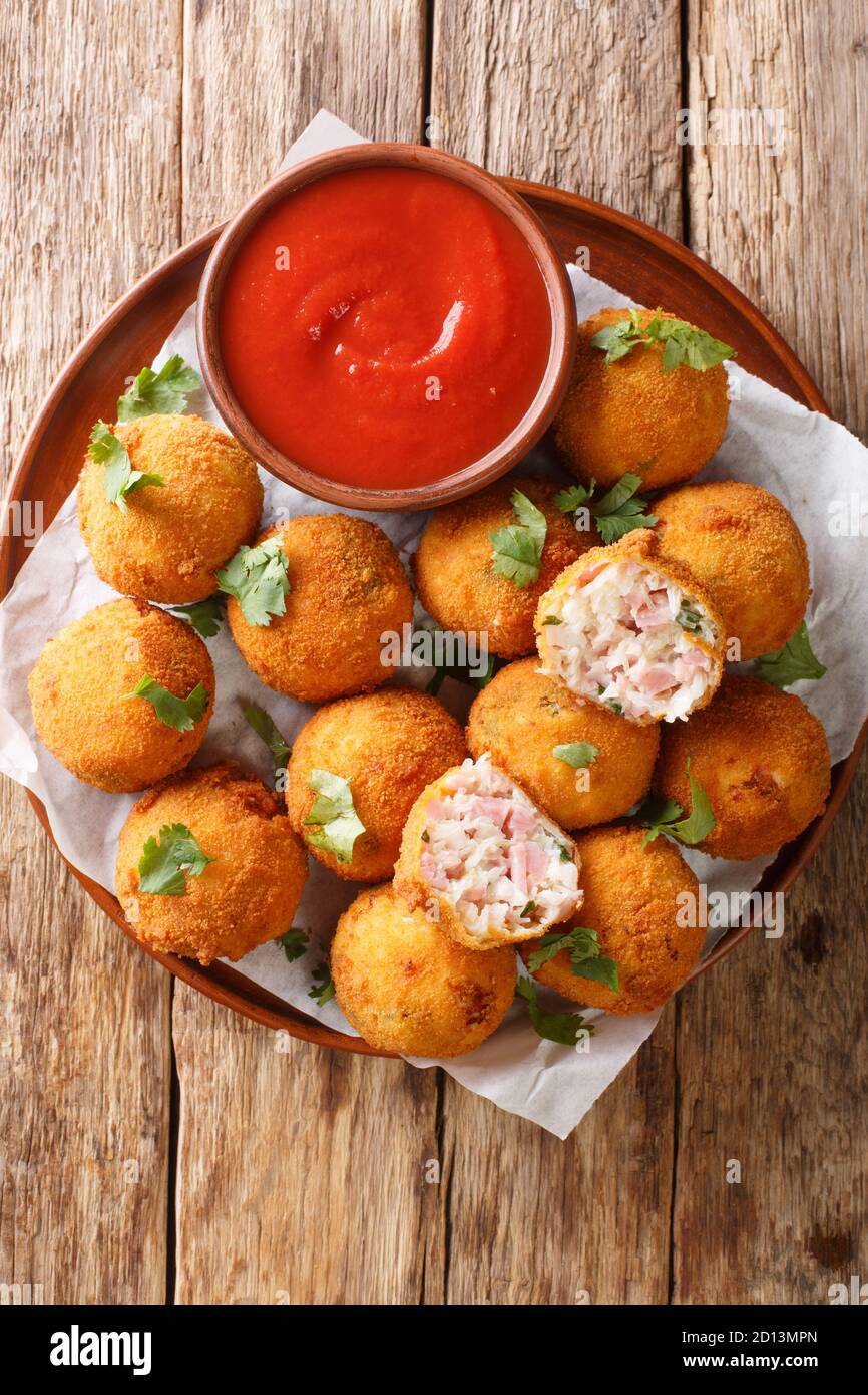 Deep fried sauerkraut balls with ham closeup in a plate on the table. vertical top view from