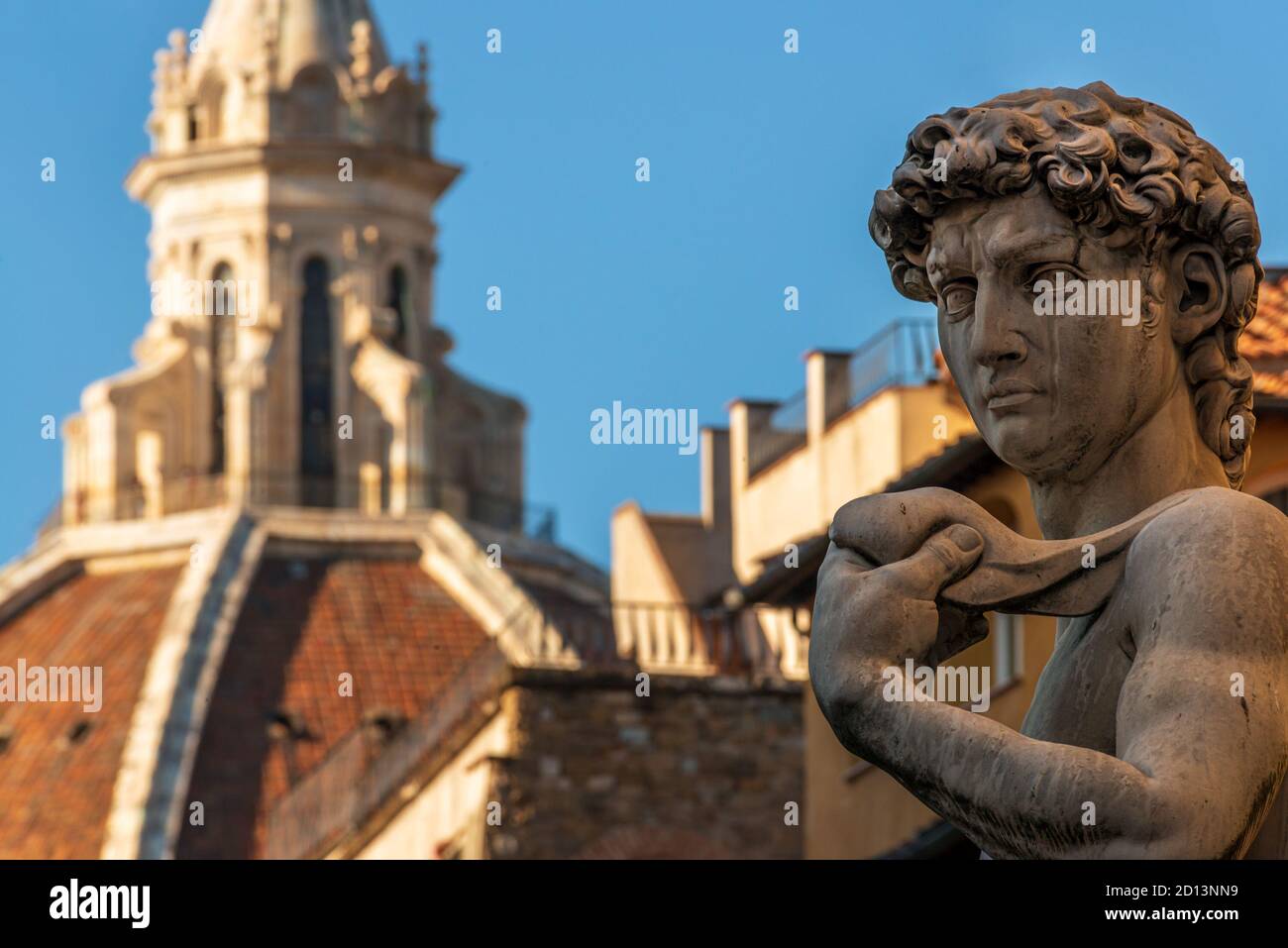 the statue of Michelangelo’s David with the cathedral dome of Florence in the background, shot from piazza della Signoria - Florence (Italy) Stock Photo