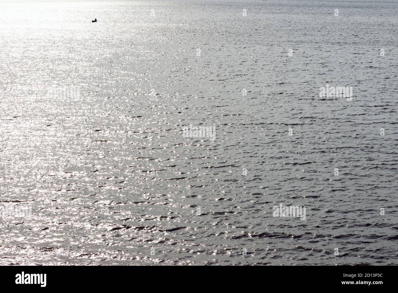 Early in the morning water ripples on a surface lake in the distance a ...