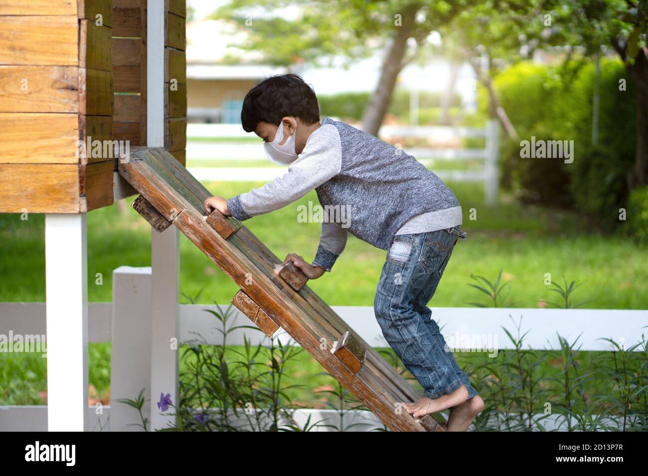 4-5 years old Asian Little boy climbing ladder on playground. Stock Photo