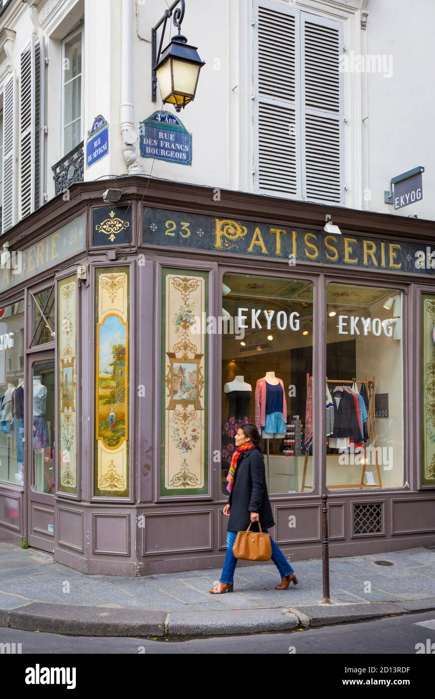 Woman walks past clothing store in the Marais, Paris, France Stock Photo