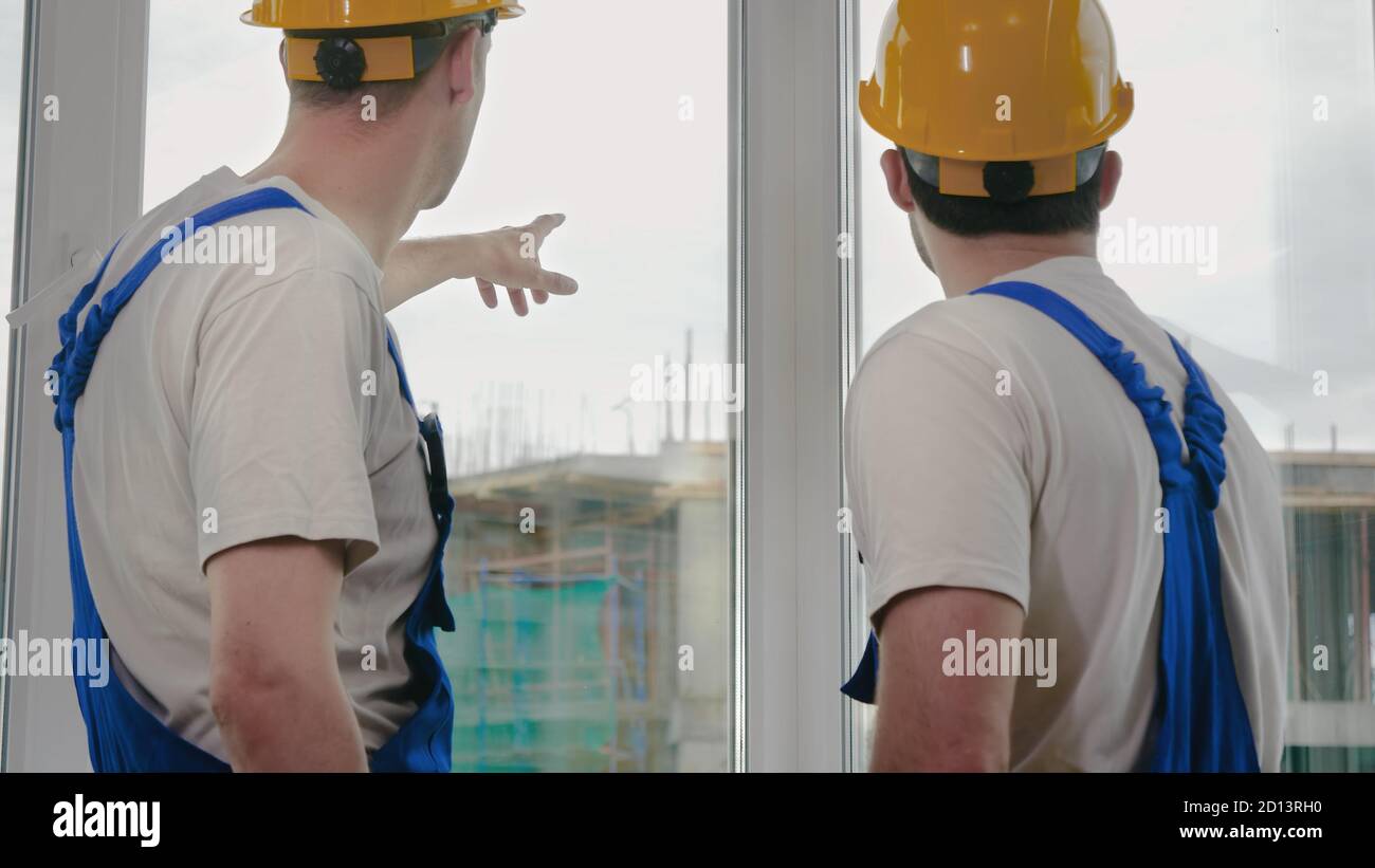 Supervisor showing something to colleague at construction site. Stock Photo