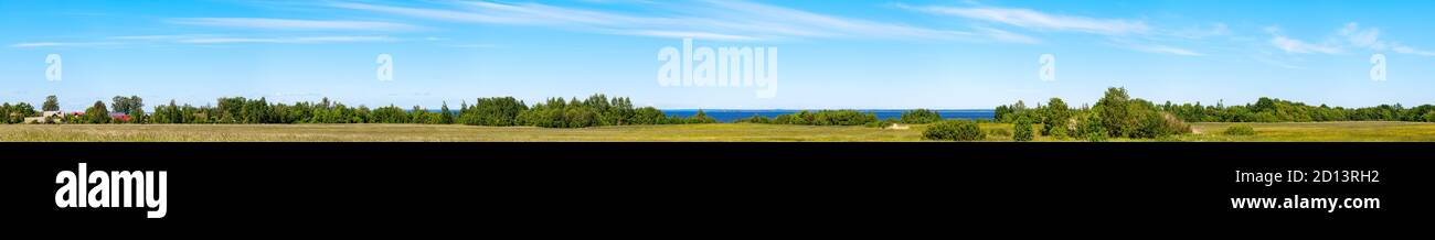 Extra wide panoramic landscape. Summer field view under cloudy sky at sunny summer day, coast of Gulf of Finland Stock Photo