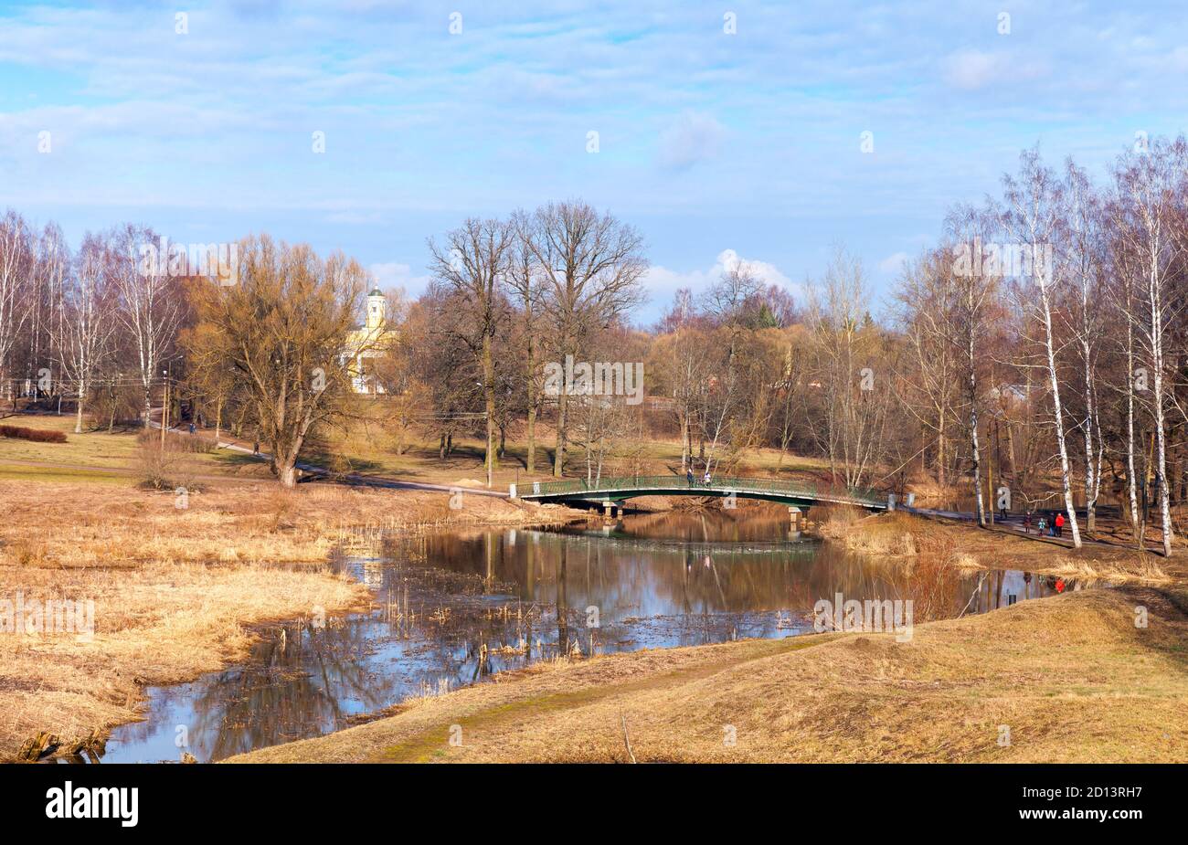 Rural Russian landscape with green bridge over small river, natural photo taken at sunny spring day Stock Photo