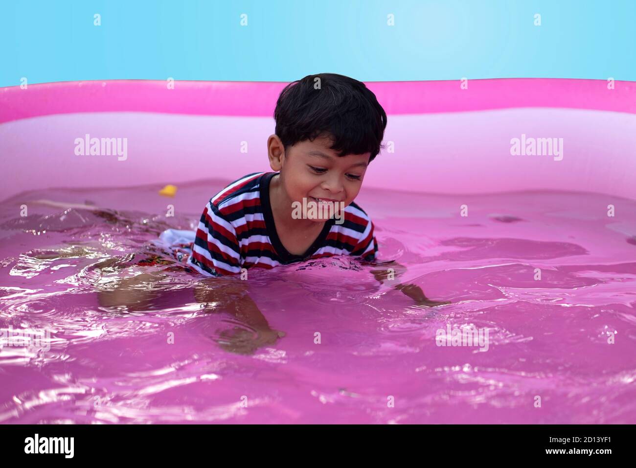 Asian boy playing in a kid rubber pool Stock Photo