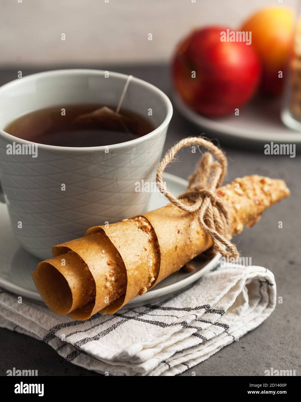 Healthy snack closeup. Mug of tea and Apple homemade candy, on the background of red apples