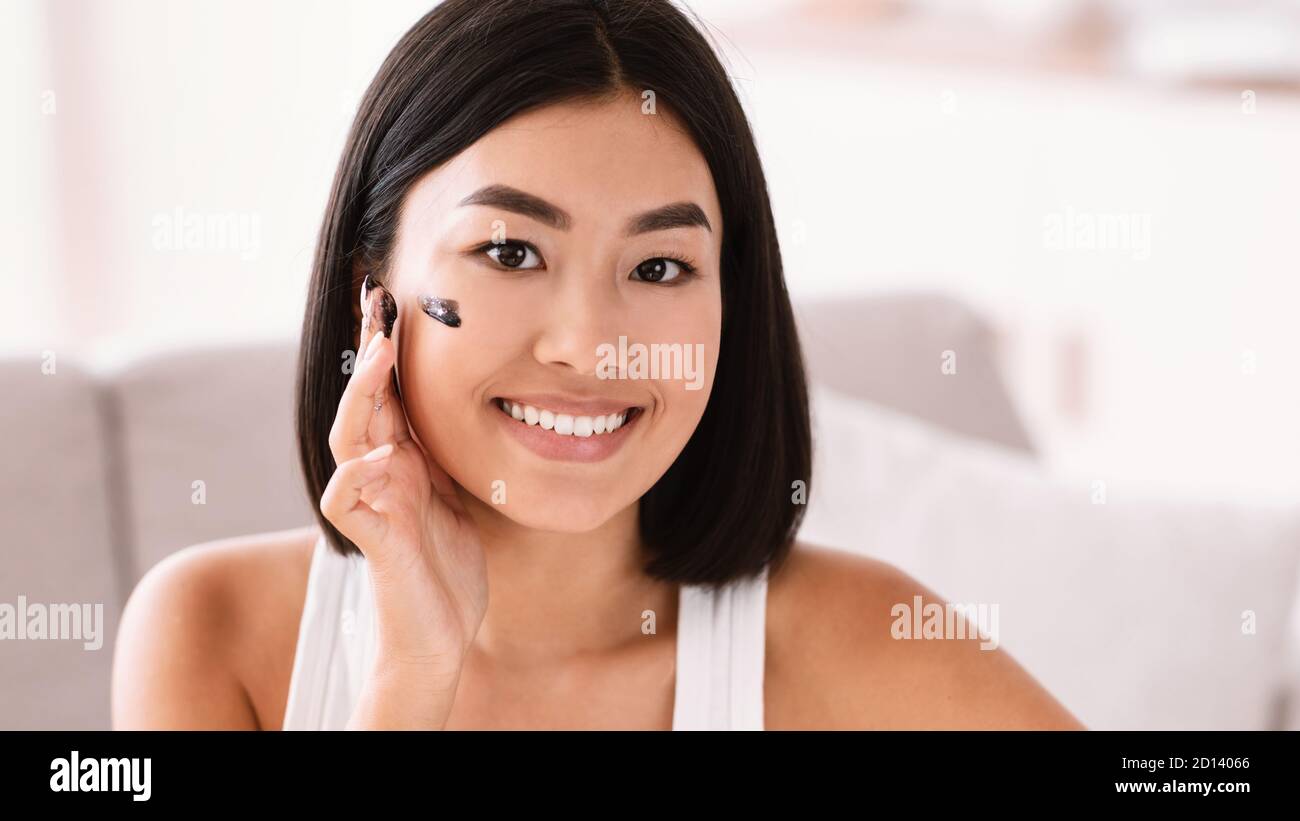 Portrait of asian woman cleaning her face with scrub Stock Photo