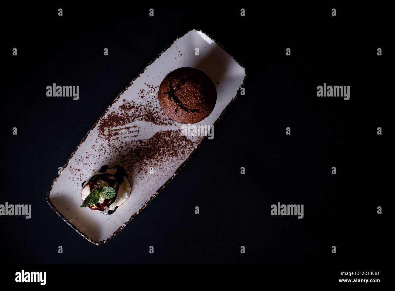 Chocolate brownie with vanilla ice cream on a rectangular white plate ...