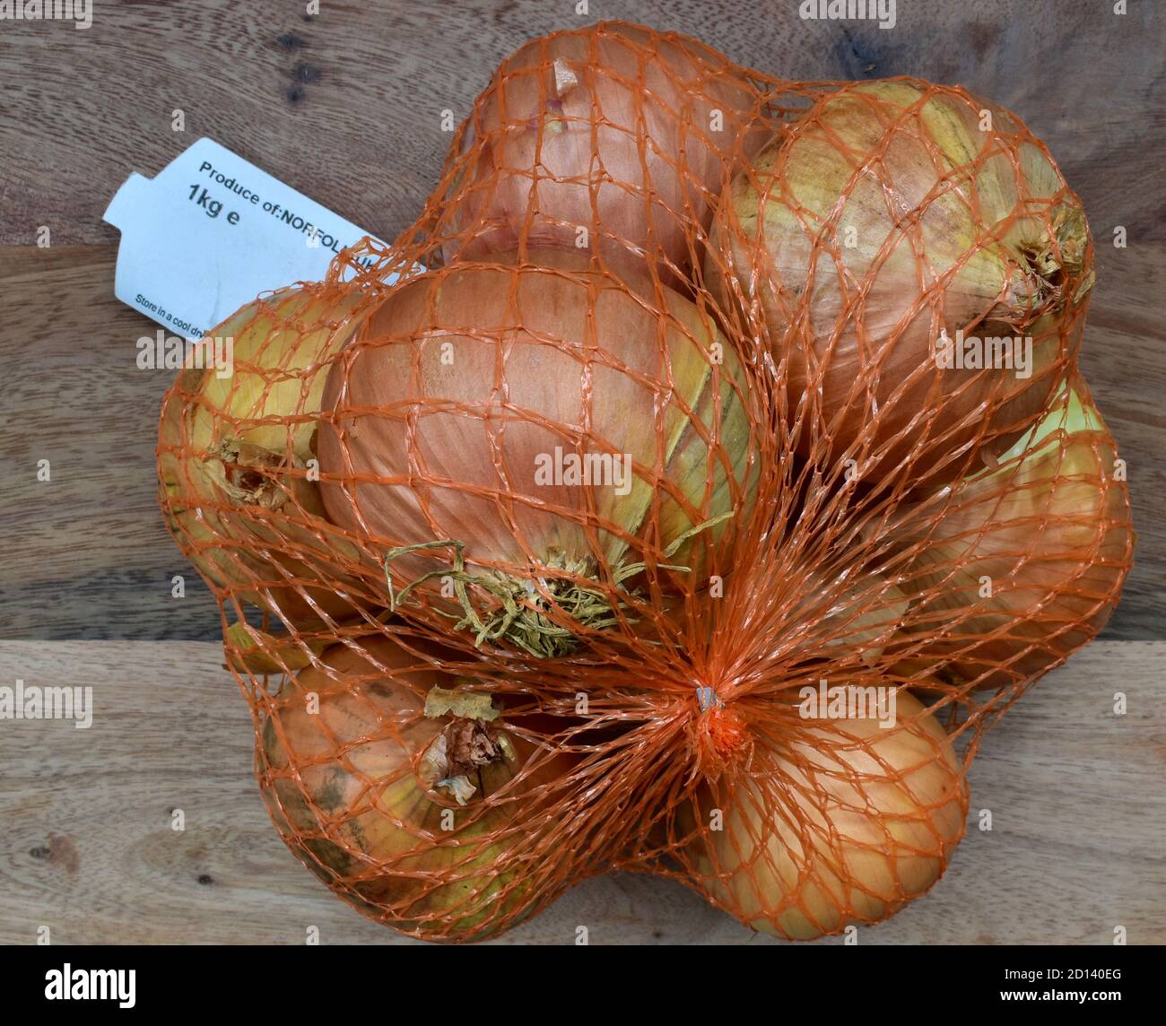 Onions, fresh, in plastic netting from a Norfolk farm supplier. Stock Photo