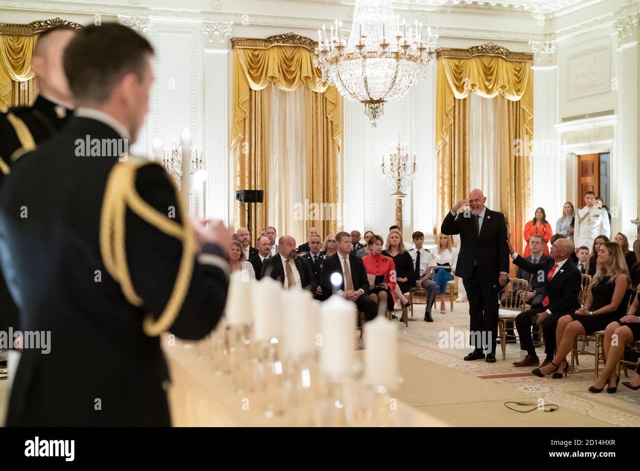 White House Reception to Honor Gold Star Families. A Gold Star family  member stands  and salutes as the name of their loved one is read aloud and a remembrance candle lit at a reception to honor Gold Star Families Sunday, Sept. 27, 2020, in the East Room of the White House. Stock Photo