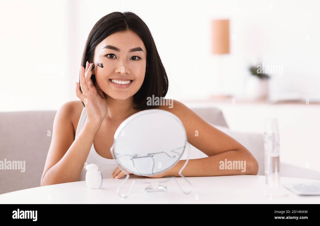 Portrait of asian lady cleaning her face with scrub Stock Photo