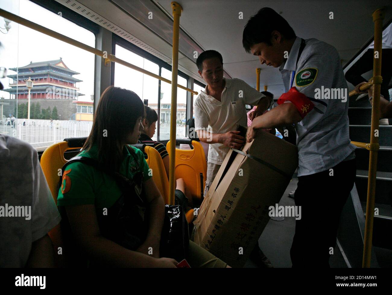 A bus conductor checks a passenger's bag on a bus at the Qianmen district in Beijing August 1, 2008. Bus conductors began checks on passngers' belongings on Friday as part of heightened security ahead of the Beijing Olympics that will begin August 8.    REUTERS/Alvin Chan (CHINA) (BEIJING 2008 OLYMPICS PREVIEW) Stock Photo