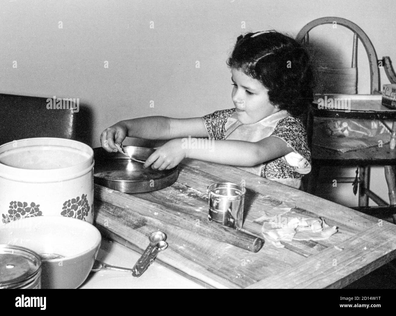 Vintage 1950s Little Girl Helps in the Kitchen, USA Stock Photo
