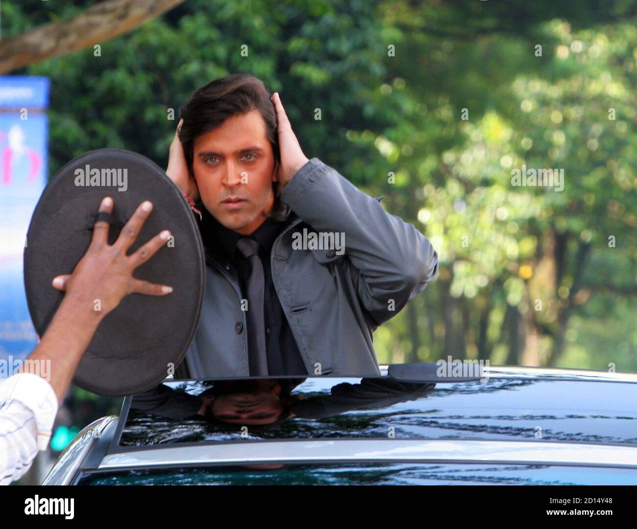 Indian actor Hrithik Roshan smoothens his hair at the Bollywood film set of  