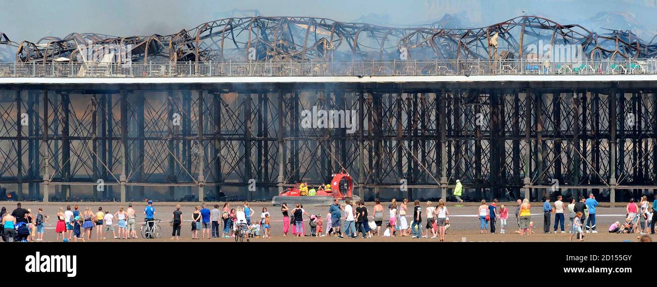 Holiday makers look at the Grand Pier at Weston-Super-Mare in south west England July 28, 2008. Firefighters were called to a large blaze that swept through the historic pier at the Somerset seaside resort of Weston-super-Mare on Monday, police said. Flames and thick black smoke engulfed the structure and could be seen from the M5 motorway, several miles from the coast, a fire brigade spokeswoman said. REUTERS/Toby Melville (BRITAIN) Stock Photo