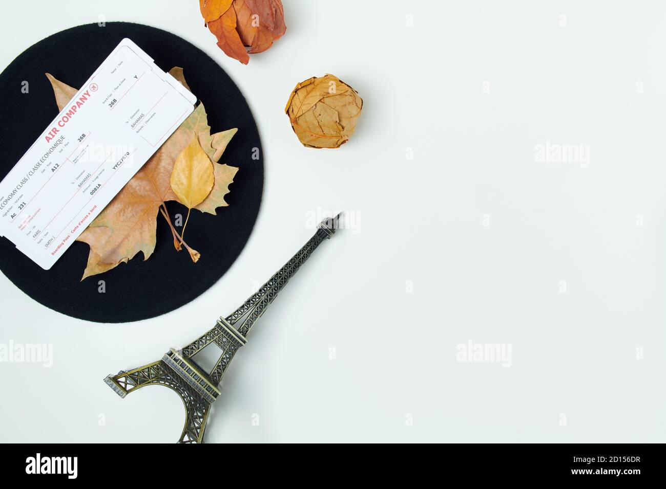 Hello october. autumn background with leaves, air tickets, eiffel tower travel souvenir and beret on white background. Stock Photo