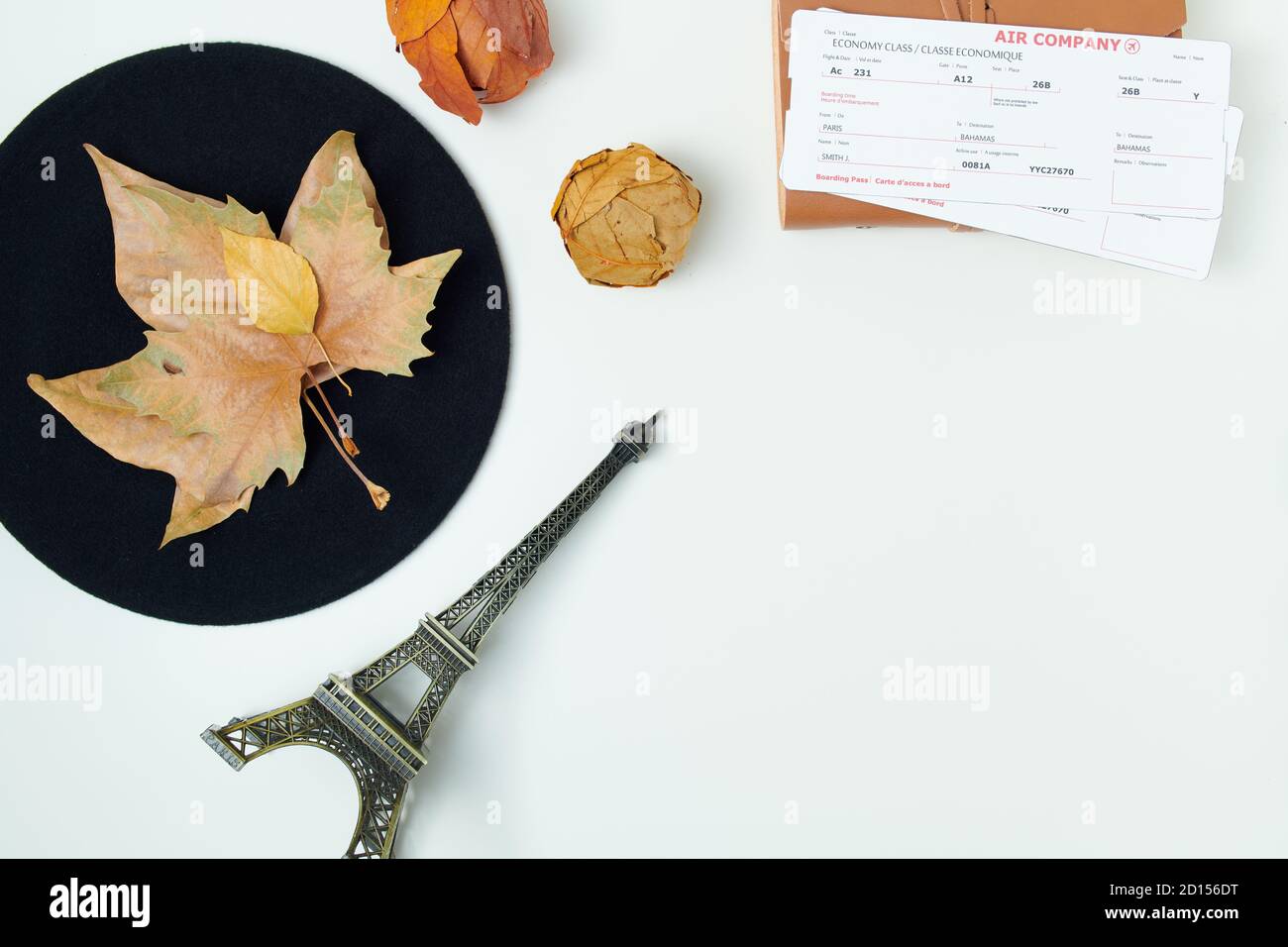 Hello october. autumn background with leaves, air tickets, eiffel tower travel souvenir and beret on white background. Stock Photo
