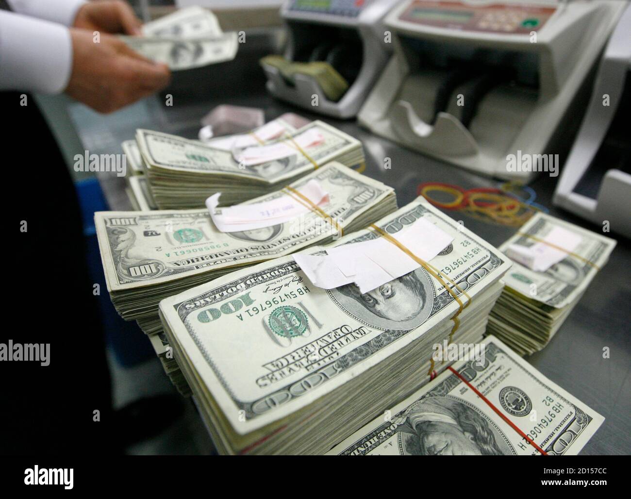 A bank employee counts one hundred dollar notes at a bank in Seoul February  26, 2009. South Korea on Thursday unveiled a string of initiatives aimed at  spurring foreign investment in its