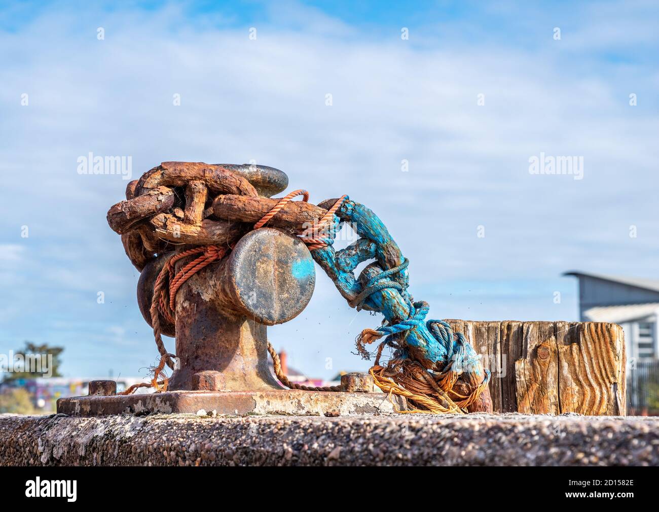 A rusty old chain on a harbour wall capstan. Stock Photo