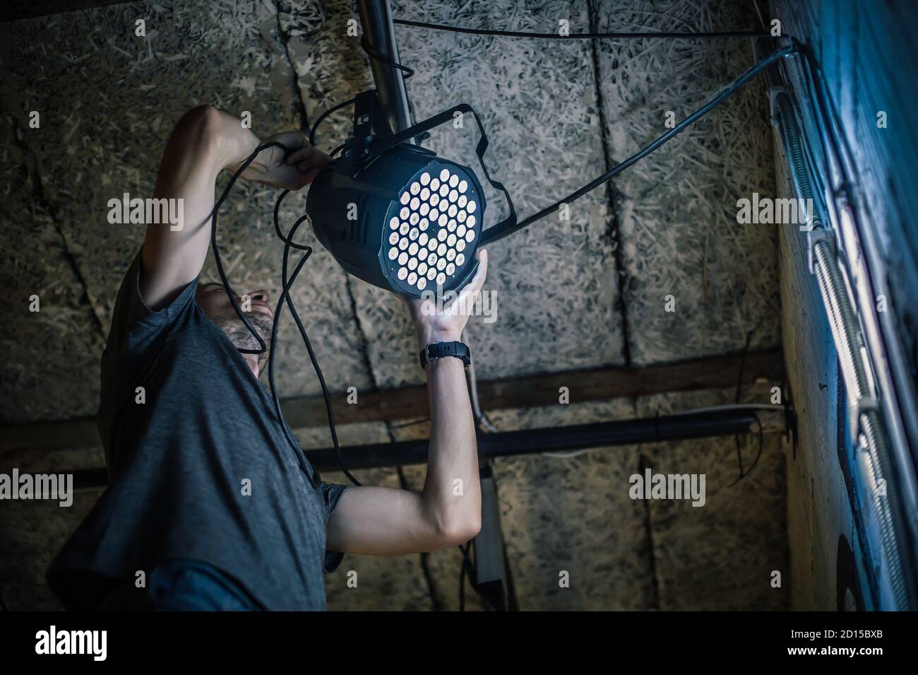 Theater lighting technician electric engineer adjusting focus of