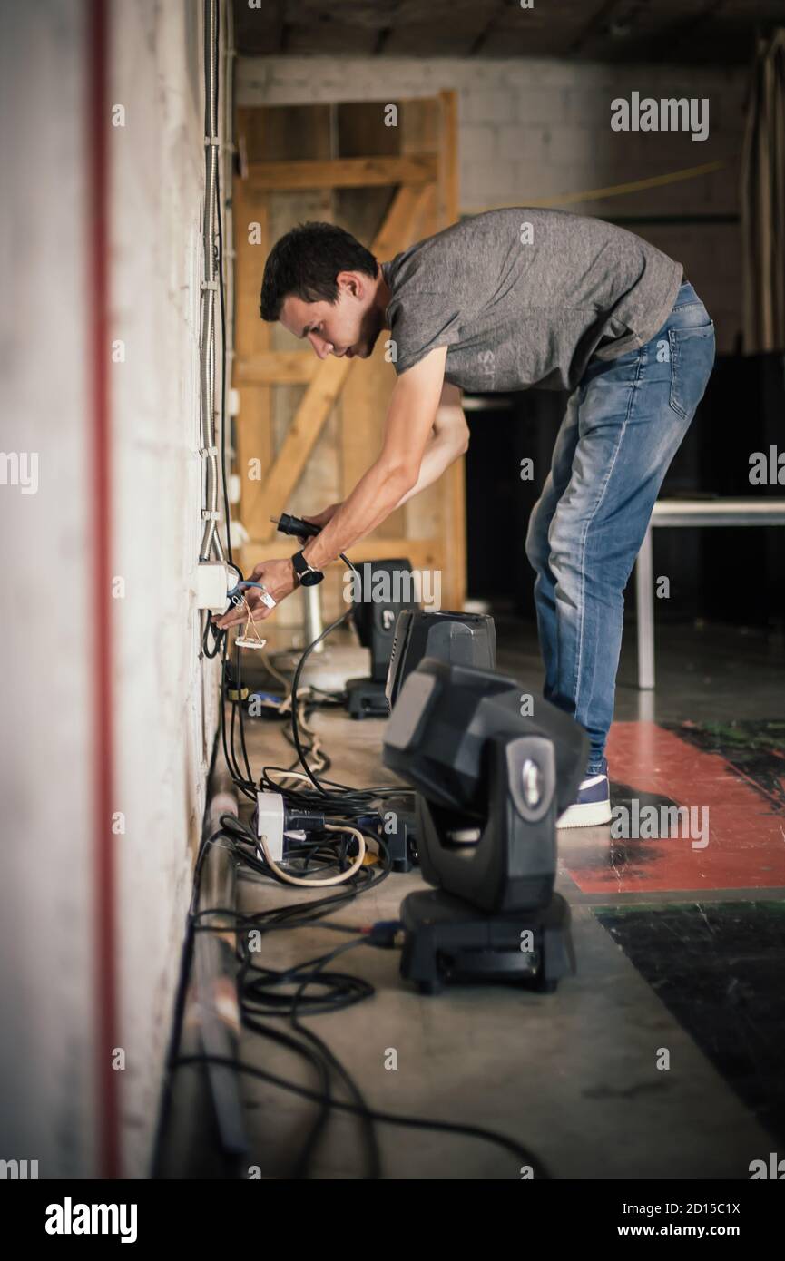 Theater lighting technician electric engineer adjusting focus of