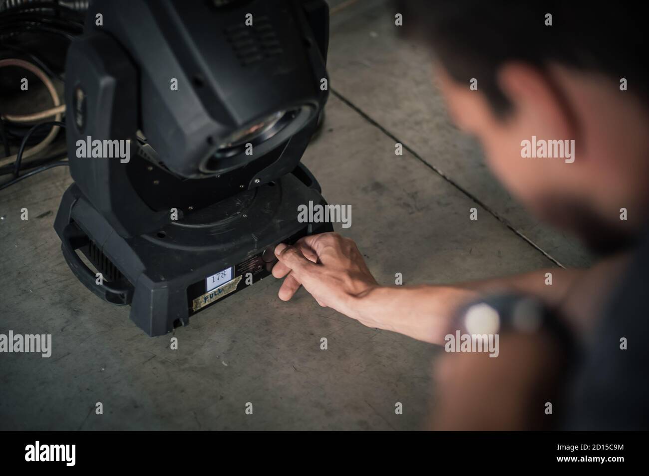 Theater lighting technician electric engineer adjusting focus of