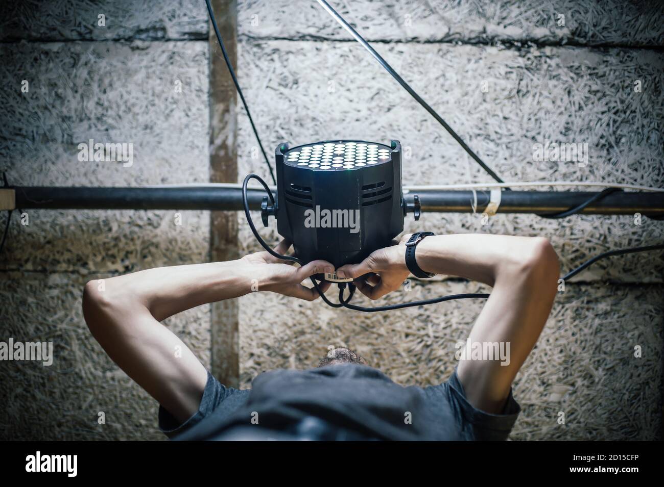 Theater lighting technician electric engineer adjusting focus of