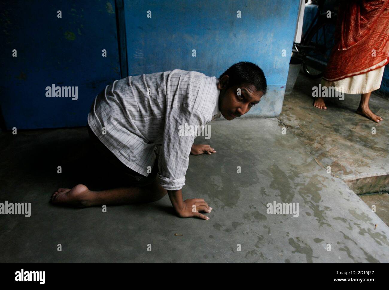 Chhatu Sha, 21, who is suffering from polio, crawls inside his house in the northeastern Indian city of Siliguri June 21, 2008. India has recorded the second highest number of polio cases in the world this year, with 268 cases so far, against 272 in Nigeria, according to the latest World Health Organization data. Polio, which is incurable, leads to paralysis, and death occurs in about 5-10 percent of patients. The virus is transmitted through the faecal-oral route in unhygienic conditions if food is eaten with unwashed hands. REUTERS/Rupak De Chowdhuri (INDIA) Stock Photo