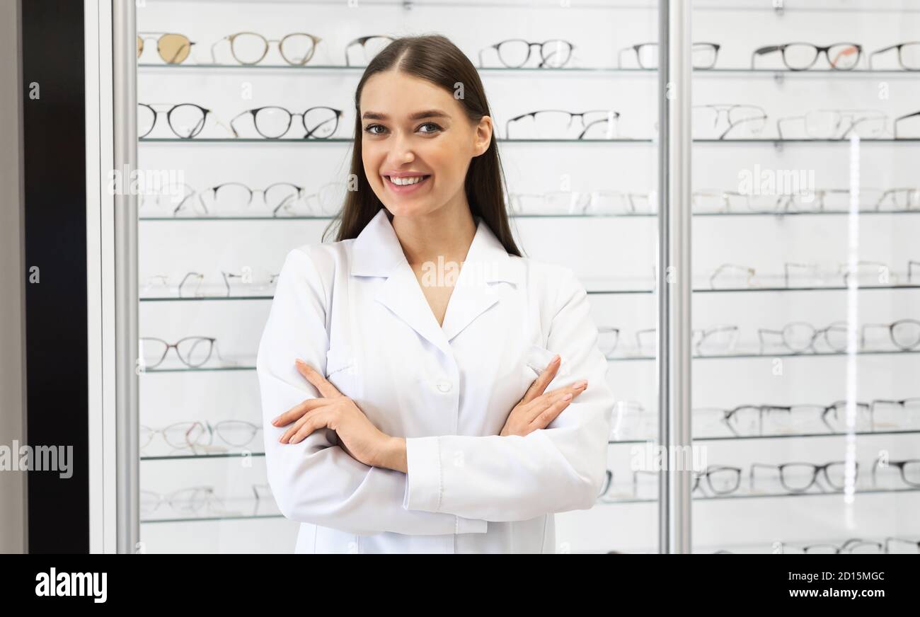 Happy female optometrist standing in optics store Stock Photo