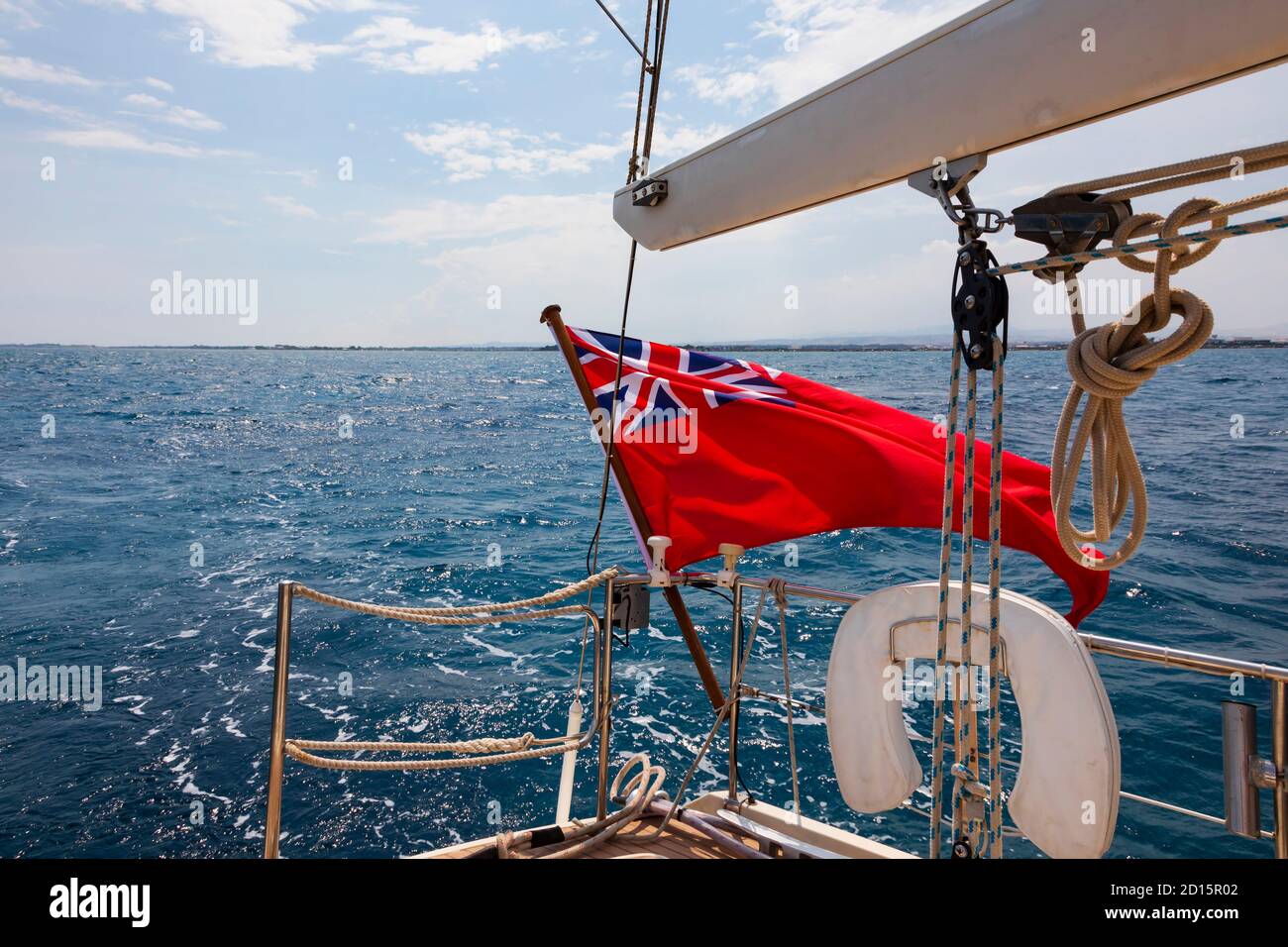 British Red Ensign flag flying on the stern of a yacht under sail in the Mediterranean Sea, off the coast of Cyprus. Cyprus Stock Photo