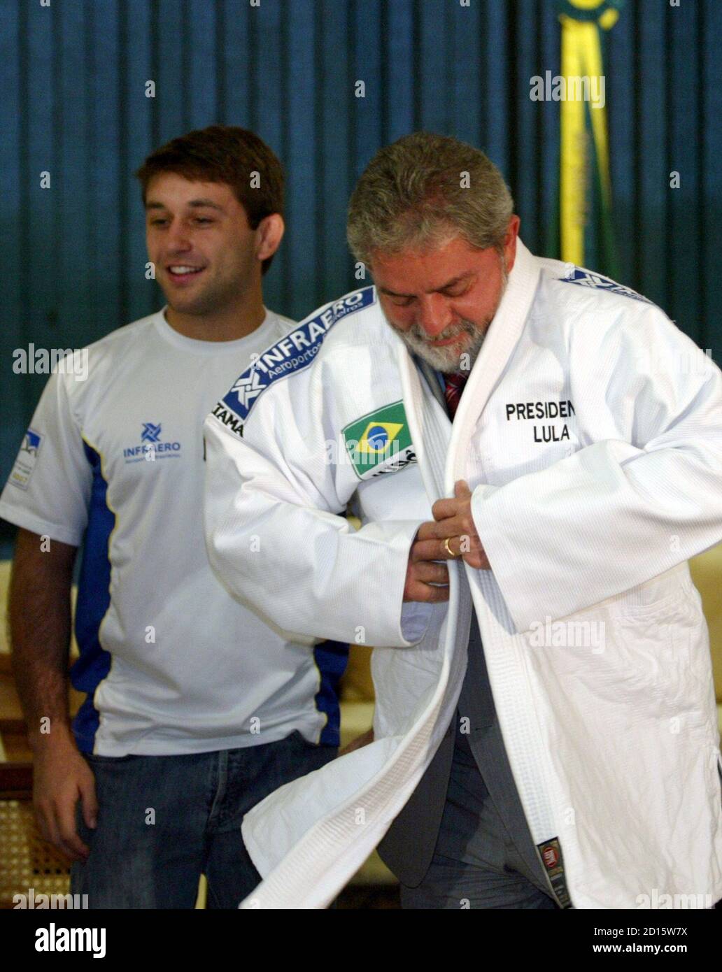 Brazil's President Luiz Inacio Lula da Silva (R) wears a judo jacket as  Brazilian National Judo member Joao Derly Junior watches during a meeting  with the Brazilian nationa judo squad at the