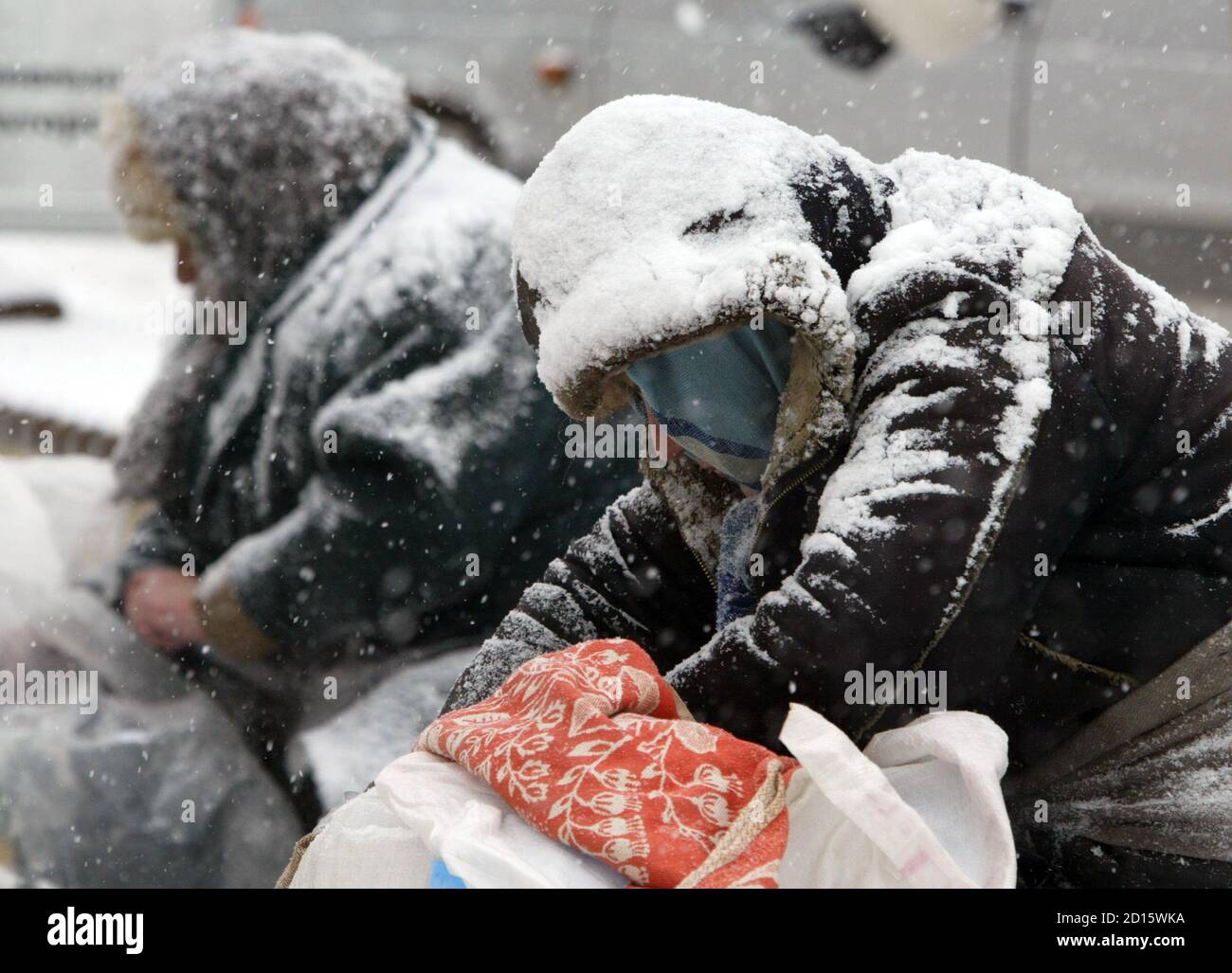 Street vendors sit in the street of Russia's southern city of Stavropol  during a heavy snowfall, February 7, 2006.Temperature in Stavropol region  dropped to minus 11 degrees Celsius (12.2 Fahrenheit) on Tuesday.