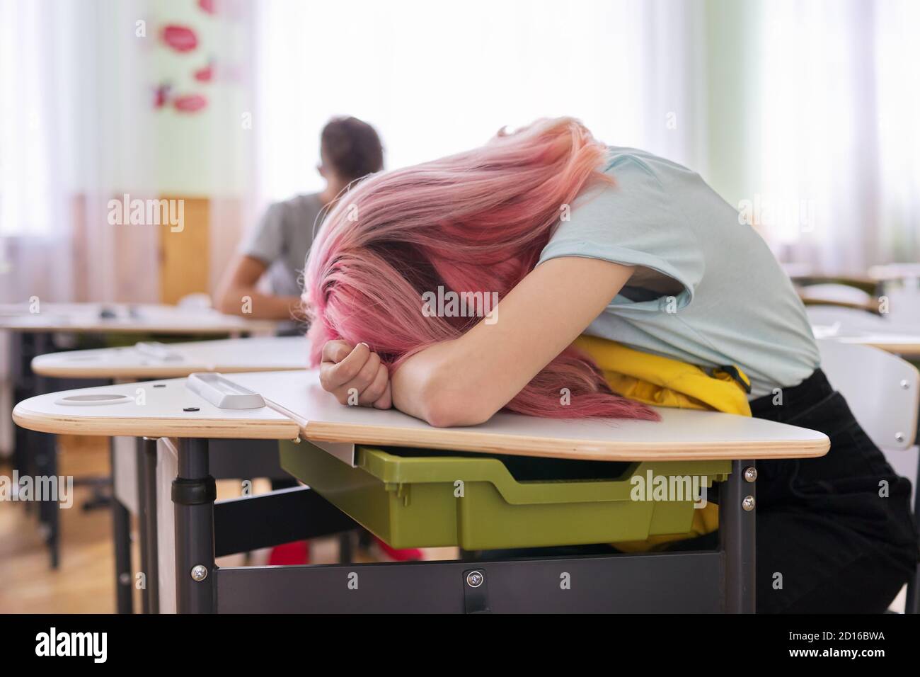 Tired girl teenage student asleep on her desk Stock Photo