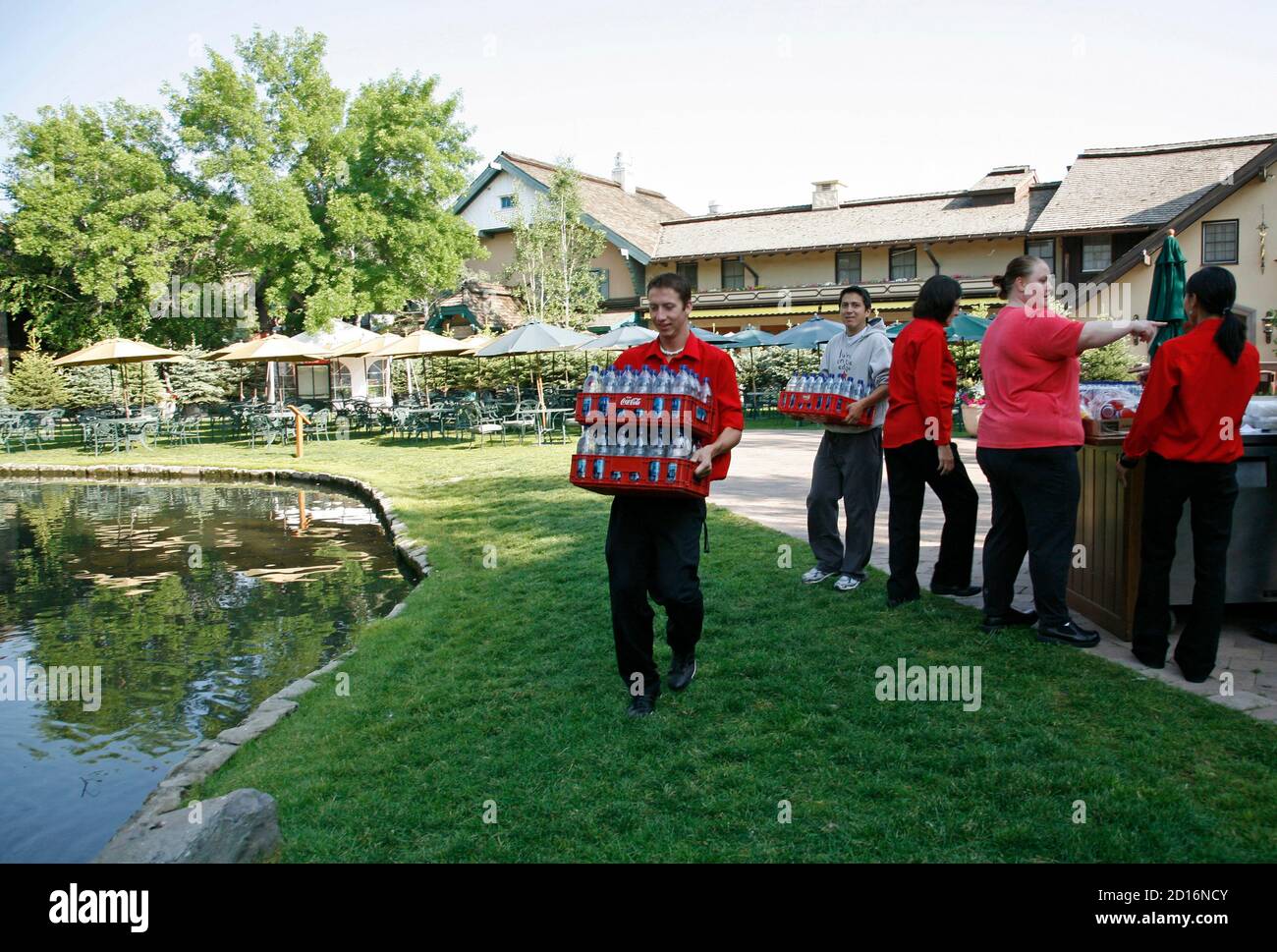A worker carries water past the duck pond where attendees at the 26th annual Allen & Co conference will lunch in Sun Valley, Idaho July 8, 2008. The deteriorating U.S. economy and slumping stock prices will frame discussions among top media and technology executives at the conference.  REUTERS/Rick Wilking (UNITED STATES) Stock Photo