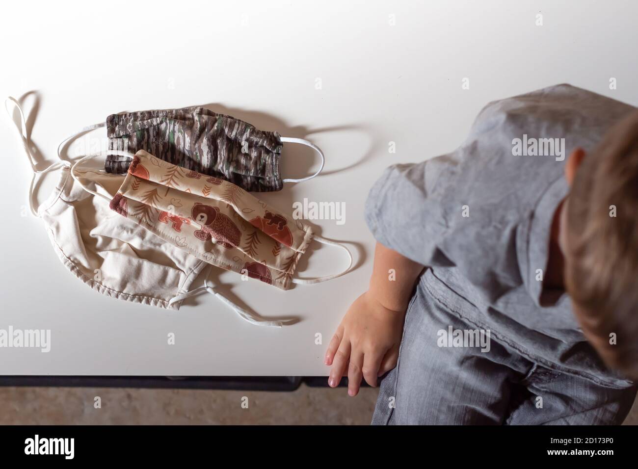 child sits with family non-medical face masks to prevent cover-19 Stock Photo