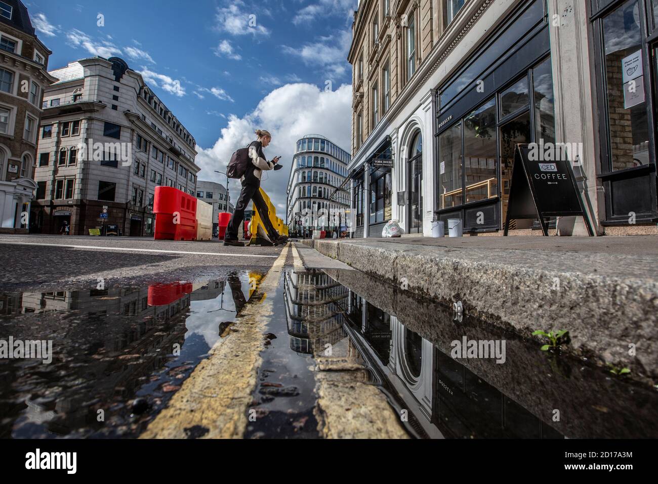Buildings reflected in a puddle in the road at Queen Victoria Street, City of London, Central London, England, UK Stock Photo
