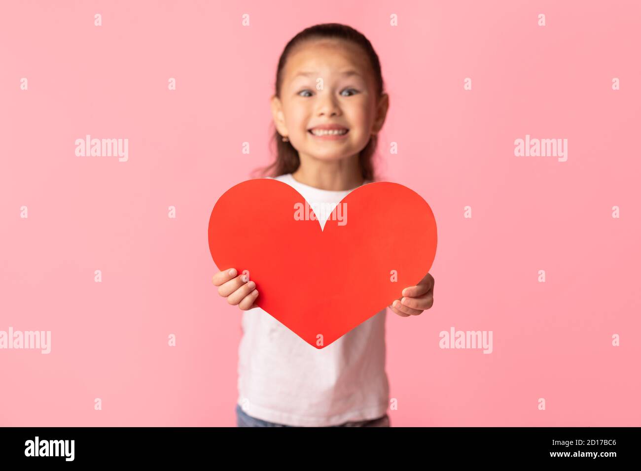 Asian girl holding red paper heart in hands Stock Photo - Alamy