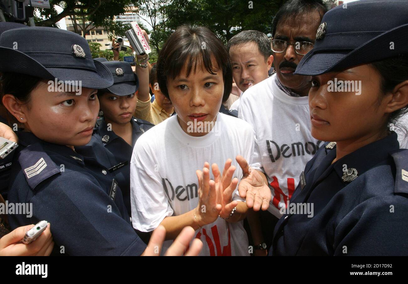 police-prevent-chee-siok-chin-c-sister-of-secretary-general-of-the-tiny-opposition-singapore-democratic-party-sdp-chee-soon-juan-from-walking-down-a-street-in-singapore-september-16-2006-chee-soon-juan-led-a-rally-in-a-city-park-in-defiance-of-a-government-ban-on-saturday-to-protest-against-curbs-on-free-speech-and-highlight-the-countrys-widening-income-gap-reutersvivek-prakash-singapore-2D17D92.jpg