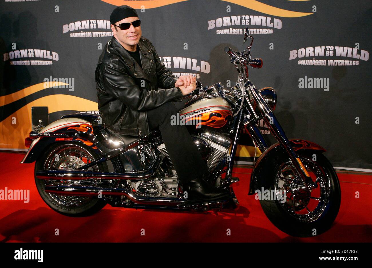 U.S. actor John Travolta poses for photographers on a Harley Davidson  motorcycle upon his arrival for the German movie premiere of "Born to be  Wild" in Munich April 2, 2007. REUTERS/Michaela Rehle (