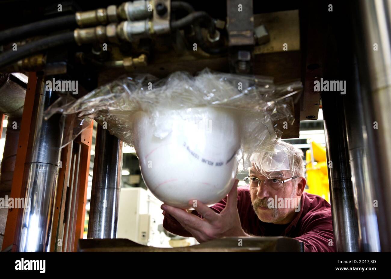 An employee looks at a helmet made from Dyneema fibre at the Dyneema plant  in Heerlen November 12, 2007. To ensure that their cockpit doors were  bullet proof, airlines turned to Dyneema,